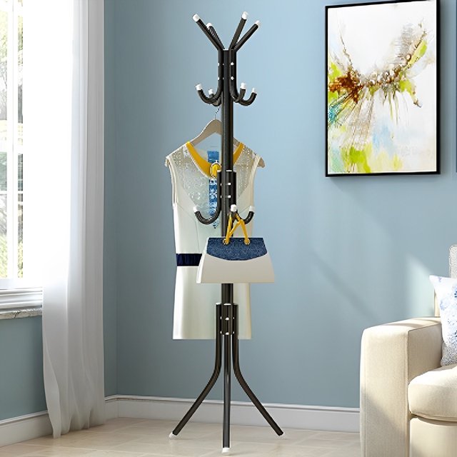 perchero de pie perchero de pie de metal perchero de pie independiente de 3 capas árbol de salón con 12 ganchos soporte para colgar ropa que ahorra espacio soporte multifuncional para bolso de mano pa Perchero de pie negro de metal con base de tres patas y diseño tipo árbol, vista frontal que muestra 12 ganchos en tres niveles y tapas plásticas en los extremos; sostiene un vestido y bolsos en una sala junto a un sofá y ventana. También suele usarse para organizar sombreros y carteras en pasillos o entradas.