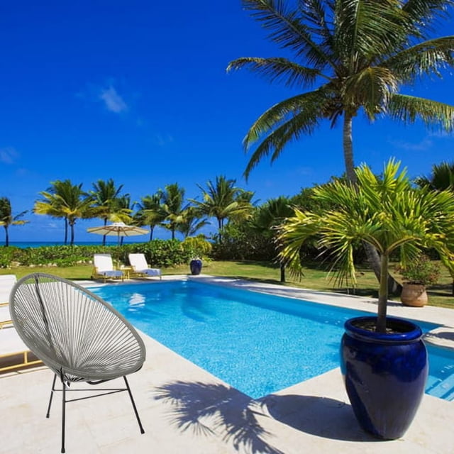 Acapulco style Costa Lounge Chair in gray wire design with black metal legs placed beside a swimming pool surrounded by palm trees and tropical plants.