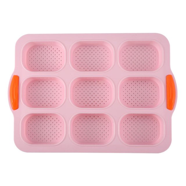 Fankiway 9 Oval Baguette Mold French DIY Small Bread Bakeware Mold Non-Stick Baking Tools. A pink silicone mold with nine oval cavities, each perforated for even baking. Features orange side handles for easy grip. Suitable for baking baguettes, biscuits, and other small bread items. Non-stick, durable, and easy to clean.
