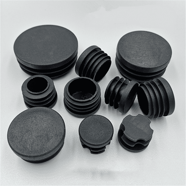 200 piezas tapones redondos de plástico de tamaño mixto, conjunto de tapones multicolor (negro y blanco) con múltiples diámetros interiores y nervaduras internas, perfiles planos y acanalados visibles; adecuados como tapas para extremos de tubo y deslizadores para patas de mesa, silla o taburete, sobre fondo claro.