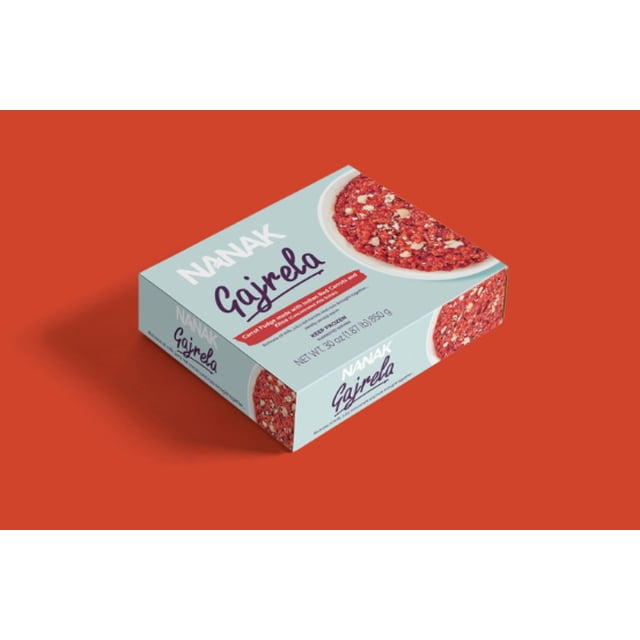 Nanak Gajrela traditional Indian carrot pudding dessert box featuring slow-cooked grated carrots with milk, sugar, and ghee on light blue packaging against a red background, suitable for festive occasions or comforting treats.