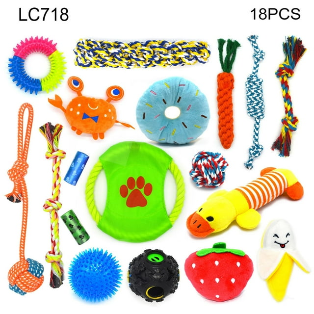 combinación de juguetes para perros, juguete de cuerda de algodón para mascotas, juguete para perros, juguete de cuerda para perros con juguete para mascotas domésticas set de 18 piezas visto desde arriba: surtido colorido de mordedores y peluches que incluye cuerdas trenzadas y nudos, disco verde con huella roja, pelota negra texturizada, pelota azul con púas, dona de peluche azul, fresa roja, banana sonriente, zanahoria de cuerda y anillos masticables sobre fondo blanco. A menudo usado para juegos interactivos y entrenamiento ligero.