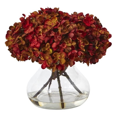 Nearly Natural Hydrangea with Vase Silk Flower Arrangement Petite blooming hydrangea bundles in brilliant autumnal colors welcome the new season. Handcrafted and finely shaped  the mixed hues of this arrangement mimic a true hydrangea. With leafy green stems and faux water vase  this arrangement is ready for display. Place the flowers next to candles and books for the perfect coffee table vignette. Height: 8.5 in. Depth: 9 in. Width: 9 in. Pot Size: H: 5.75 In. W: 6.25 In. D: 6.25 In. Planter  vase or basket is included in the height.
