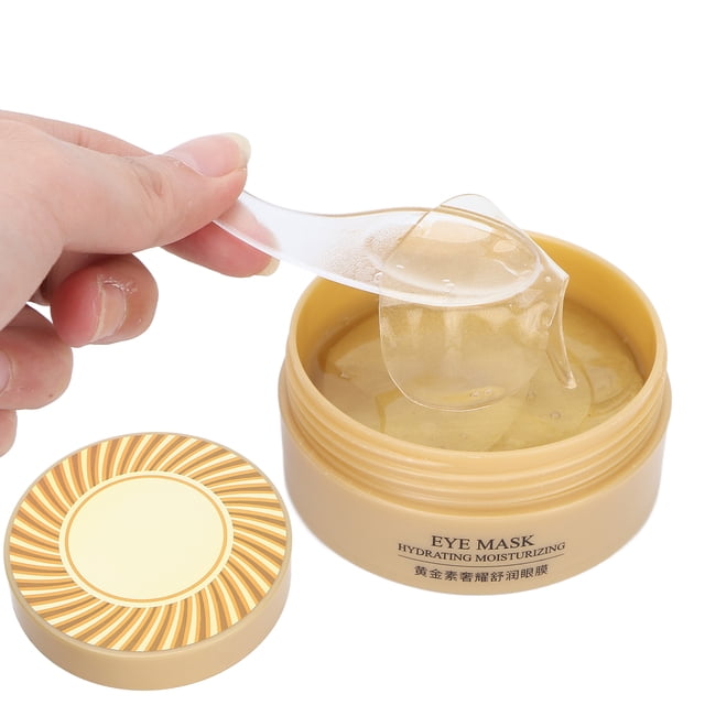 parches para los ojos anggrek 60 uds nutritivos para eliminar ojeras frasco beige abierto con parches hidrogel dorados en forma de media luna y una espátula transparente levantando un parche húmedo; tapa decorada y texto "EYE MASK Hydrating Moisturizing" visible, enfoque cercano, adecuado para hidratación y cuidado superficial del contorno ocular y a menudo usado para refrescar la piel durante viajes.