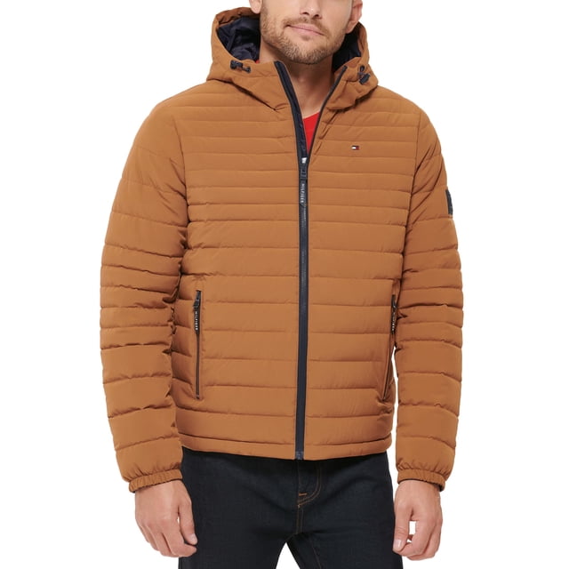 chaqueta tommy hilfiger de poliéster elástico con capucha, plegable, para hombre Nuthatch, vista frontal centrada de torso masculino con capucha ajustable; silueta acolchada horizontal, cierre de cremallera frontal negro, dos bolsillos inferiores con cremalleras y bolsillo interior de seguridad; tejido de mezcla de poliéster de acabado mate y logo bordado en el pecho. Adecuada como chaqueta acolchada ligera para clima fresco y frecuentemente usada para viajes urbanos.