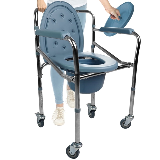 silla de baño comodo plegable con ruedas gambimedic discapacitado silla de baño plegable Gambimedic, vista frontal 3/4; estructura de acero resistente cromado, asiento azul con tapa y abertura central, cubeta removible bajo el asiento, cuatro ruedas con freno, patas telescópicas con altura ajustable y apoyabrazos acolchados; soporta hasta 100 kg, diseño compacto y plegable para transporte y almacenaje; también suele usarse para traslado temporal del paciente dentro del hogar.