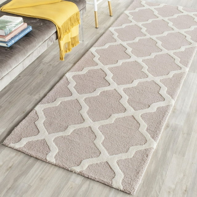 Safavieh Cambridge Liam beige runner rug with white geometric pattern on light wood floor beside gray sofa draped with a yellow throw.