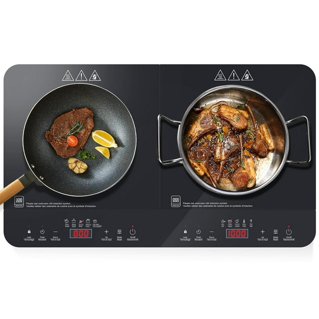 Double Induction Cooktop by LIVINGbasics featuring two burners with a sleek black ceramic glass surface. The left burner displays a frying pan with a cooked steak, lemon wedges, and garnish, while the right burner shows a pot with cooked meat and vegetables. The cooktop includes touch sensor controls, LED display, and safety icons. It offers 10 temperature and power levels, a built-in safety lock, and dual cooling fans for efficient operation. Compatible with induction-ready cookware.
