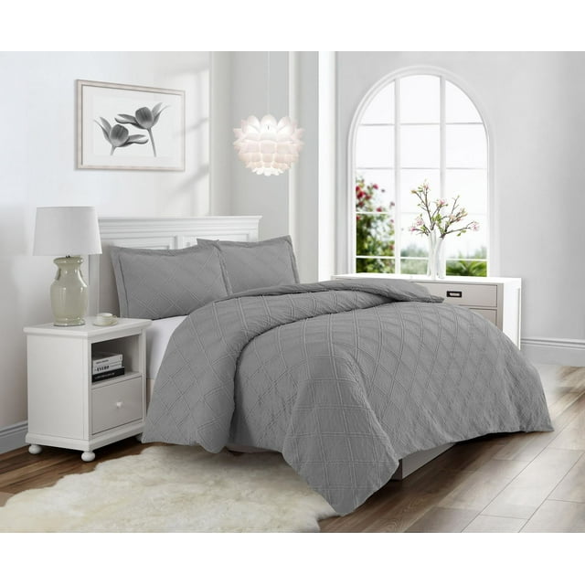 Gray Swift Home Waffle Square prewashed duvet cover set displayed on a bed in a modern, light-filled bedroom with white nightstand, lamp, and floral artwork.