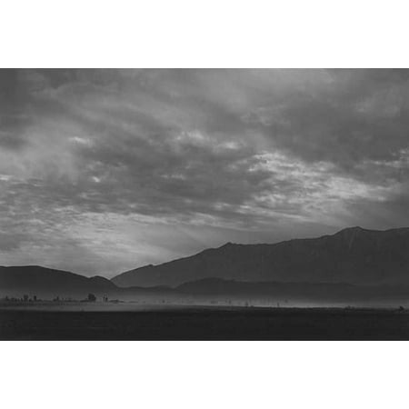 Dust storm at base of mountains under cloudy sky  Ansel Easton Adams was an American photographer best known for his black-and-white photographs of the American West  During part of his career he