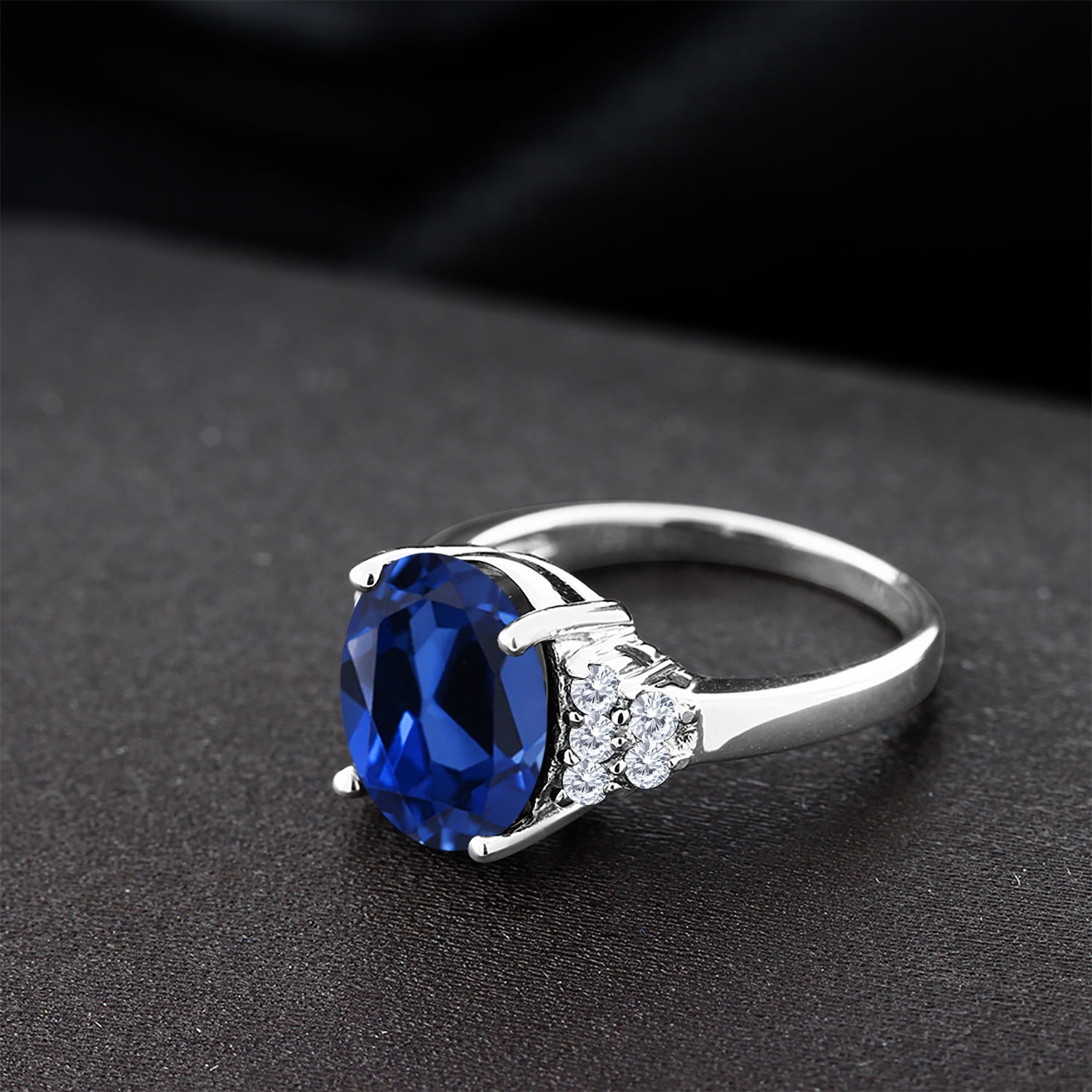 Gem Stone King 925 Sterling Silver Oval Blue Created Sapphire and White Moissanite Ring for Women (6.38 Cttw, Oval 12X10MM, Size 9)