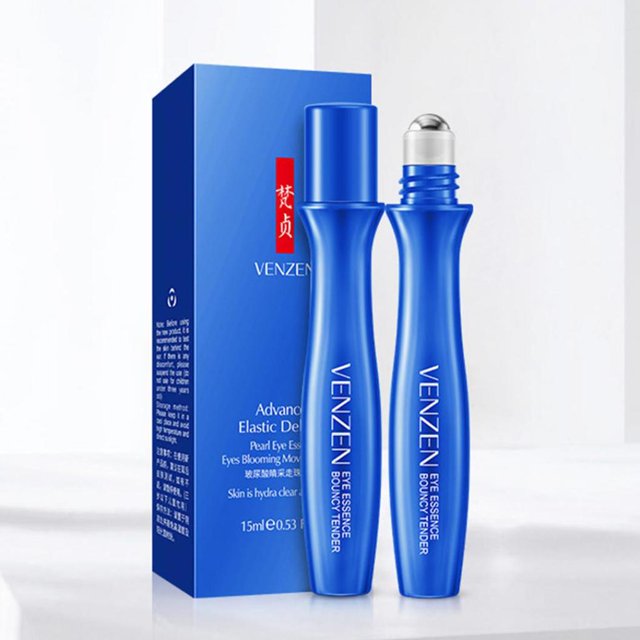 rodillo de ácido hialurónico, esencia para ojos, antihinchazón, ojeras, reafirmante para la piel, suero para ojos, cuidado de los ojos 15 ml. Vista frontal de dos frascos roll‑on azules con texto de marca; uno con capuchón y otro con aplicador metálico esférico visible, y caja azul rectangular al fondo. Envase cilíndrico para masaje periocular, indicado como suero hidratante y antihinchazón; también suele usarse para refrescar la piel fatigada en viajes.