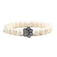 thumbnail image 1 of Pulsera con dije de huella de pata de piedra volcánica de lava negra mate natural, ideal como recuerdo para mascotas, amantes de los gatos y los perros., 1 of 2