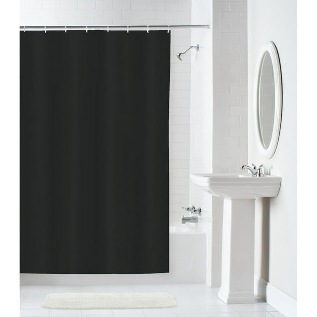 Black Hometrends 100% waterproof fabric shower curtain hanging in a bright white tiled bathroom with pedestal sink and oval mirror.