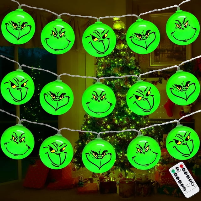decoraciones navideñas de grinch kaiyang 40 luces led 19,6 pies a prueba de agua con temporizador 8 modos muestra una guirnalda frontal de 40 esferas verdes con tres caras 3D del Grinch repetidas en cada bombilla a lo largo de cable blanco, iluminación LED verde brillante y control remoto visible; luces LED decorativas ideales para árbol de Navidad, repisa o porche.