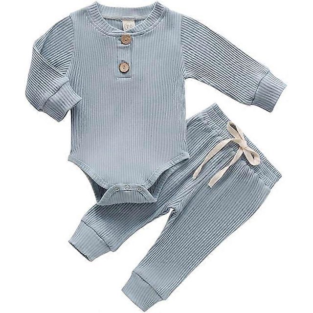 ropa de otoño para bebé recién nacido, niña y niño, conjunto de dos piezas de algodón de punto 70 cm; vista frontal centrada de mono de manga larga con dos botones en el pecho y abertura inferior con broches, pantalones a juego con cintura elástica y cordón decorativo, textura acanalada y tono azul claro sobre fondo neutro, adecuado para uso diario y fotografía. Además, su tamaño compacto lo hace adecuado para sesiones de recién nacido y como opción frecuente para regalos de temporada.