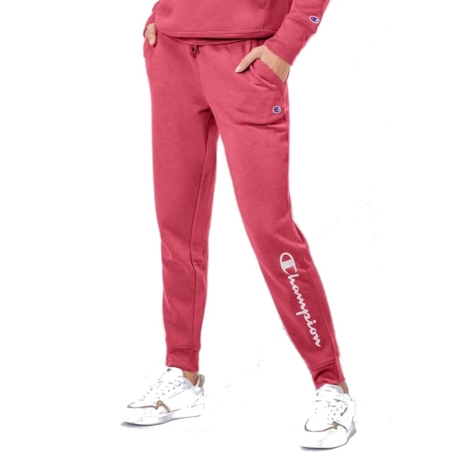 pantalón champion powerblend para mujer. episs23d14w10 fucsia s jogger deportivo fucsia, vista frontal de cuerpo entero; cintura con elástico cerrado y cordón plano, bolsillos laterales, puños elásticos en tobillos, puntadas visibles para mayor durabilidad y logo Champion en la pierna izquierda y parche en el muslo derecho. También suele usarse como prenda athleisure para salidas urbanas.