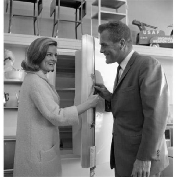 Posterazzi SAL255421027 Shop Assistant Showing Interior of Fridge to Woman Poster Print - 18 x 24 in.