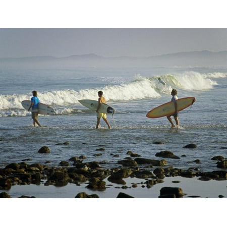Surfers Head into the Surf at Mancora on the Northern Coast of Peru Print Wall Art By Andrew