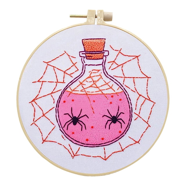 DJN Halloween Kit – & Bat Embroidery Set with hoop, thread, fabric, and tools. The image shows a completed embroidery design featuring a pink potion bottle with black spiders and orange spiderwebs, framed in an adjustable wooden hoop. Ideal for DIY Halloween decor and beginner-friendly crafting.