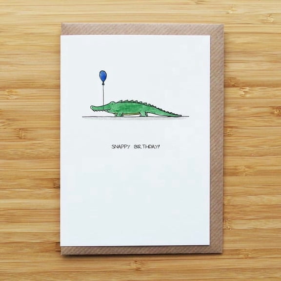 Cute crocodile birthday card with balloon and "Snappy Birthday!" text for celebrating friends or family members on their special day.
