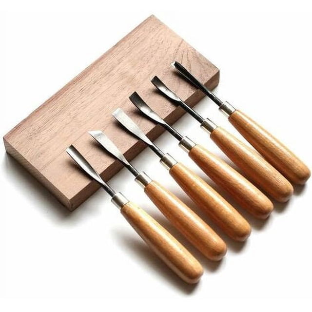 juego de 6 piezas: cinceles y cuchillos para tallar para una experiencia de escultura definitiva kit de herramientas para tallar madera — seis herramientas con mangos ergonómicos de madera de haya y hojas de acero al carbono dispuestas en fila sobre una tabla de madera, formas de corte variadas, fundas plásticas protectoras visibles y estuche de nailon incluido; ideal para manualidades y proyectos de tallado en maderas blandas por principiantes.