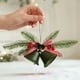 thumbnail image 5 of Adornos navideños con campanas de terciopelo rojo y lazos de hierro forjado para crear un ambiente festivo., 5 of 6