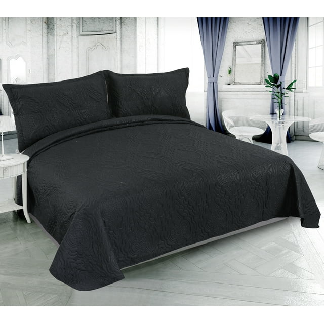Black solid embossed pinsonic coverlet bedspread and matching pillow shams displayed on a neatly made bed in an elegant, bright bedroom setting.
