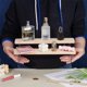 thumbnail image 3 of Estante de exhibición de madera de 2 niveles, color almendra blanqueada, pequeño modelo de mesa, soporte de acrílico, organizador de maquillaje y perfumes., 3 of 8