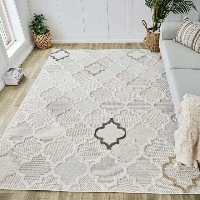 Cream beige Rug Branch Maison Moroccan indoor area rug featuring modern geometric patterns, placed on light wood flooring next to a gray sofa and decorative plants.