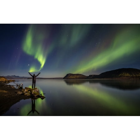 Woman enjoying the view of the Northern Lights at Lake Thingvellir Iceland Thingvellir National Park is a UNESCO World Heritage Site Stretched Canvas - Panoramic Images (9 x
