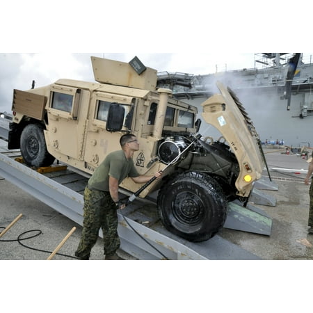 Marine uses a pressure washer to clean the underside of a Humvee hood Canvas Art - Stocktrek Images (35 x