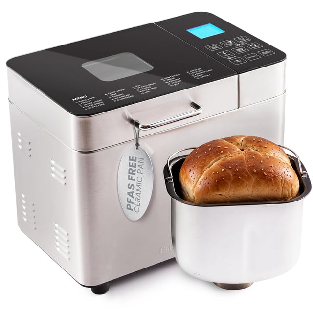 Máquina para hacer pan Elite Gourmet con bandeja cerámica de 2 lb y 19 funciones, vista 3/4 frontal: cuerpo de acero inoxidable con tapa de vidrio, panel de control táctil con pantalla iluminada y texto de programas en la tapa; bandeja cerámica Ceralast™ (etiqueta PFAS free) extraíble colocada frente a la máquina con un pan dorado horneado. Capaz de panes de 1/1.5/2 lb y temporizador hasta 15 horas; a menudo usada también para preparar masas y yogur casero.