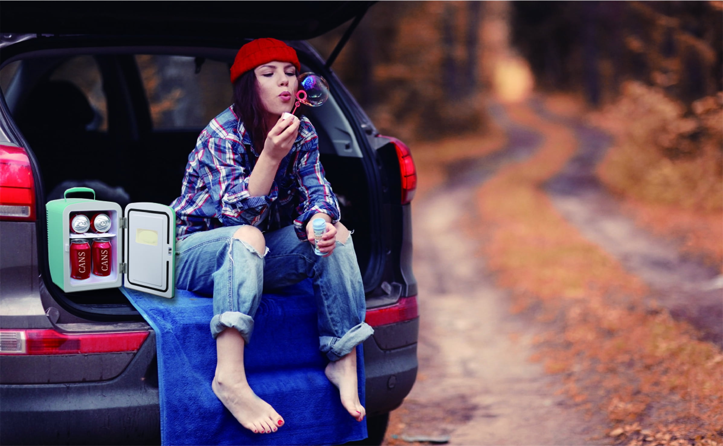 charming retro woman sitting on vintage suitcase and tv set while