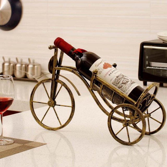 estante para copas , porta botellas , estantes para vinos exhibición de piezaza bicicletas metálicas dispensador de formas decoración blesiy soporte para botella de vino para bicicleta Bronce: estante de vino de hierro con forma de bicicleta vintage que sostiene una botella en cuna inclinada; ruedas de radios y armazón tubular con acabado bronce envejecido, dimensiones aprox. 41 cm de largo x 25 cm de alto (16.1 x 9.8 in). Adecuado para exhibición en bares, cocinas o como adorno de mesa auxiliar.