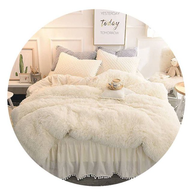 colcha chiporro peludo para 2 asientos, color blanco, 230 x 250 cm colcha blanca de pelo largo y textura mullida que cubre la cama, vista frontal centrada; incluye 2 fundas visibles en la cabecera, silueta rectangular que deja ver faldón y sábanas, dormitorio luminoso con cojines y mesa de noche. A menudo usada también como manta ligera para siestas.