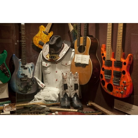 Display of guitars and clothing related to Alabama a Grammy Award-winning country music and southern rock band that originated in Fort Payne Alabama Poster