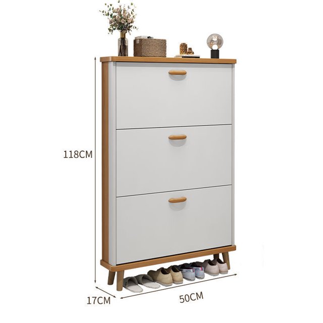 armario de zapatos ultrafino para el hogar, cubo de volteo de pared de madera maciza con 3 cajones; vista frontal 3/4, paneles blancos y marco con tiradores en tono madera, medidas 118 cm alto x 50 cm ancho x 17 cm profundidad, para montaje o apoyo en entrada, pasillo o apartamento estrecho; tablero superior con objetos decorativos y base que muestra pares de zapatos. Adecuado también para organizar bolsos pequeños o accesorios en pasillos estrechos.