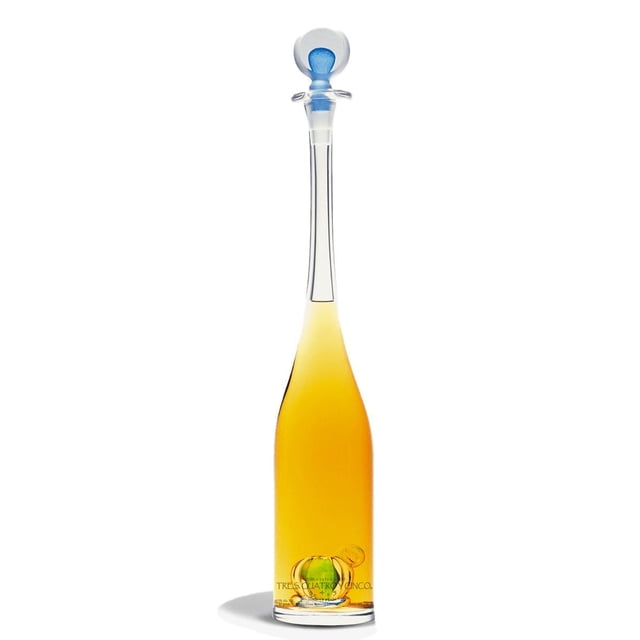 pack de 4 tequila 3, 4 y 5 añejo 750 ml 3, 4 y 5 añejo botella alta de cristal transparente con cuello largo y tapón esférico azul, líquido ámbar envejecido visible y etiqueta redonda en la base sobre fondo blanco; a menudo usado para exhibición en cavas o como botella de colección.