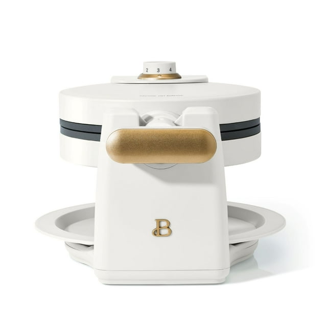 Beautiful By Drew Barrymore rotating Belgian waffle maker in white with gold handle and adjustable temperature dial.
