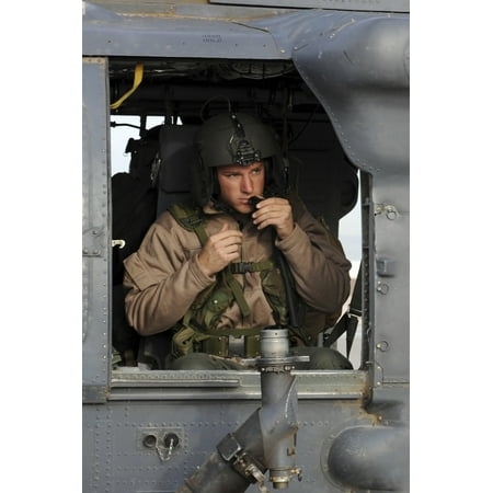 Nellis Air Force Base Nevada May 1 2009 - An HH-60G Pave Hawk helicopter aerial gunner makes final adjustments to his helmet prior to departing for a real-world rescue mission Poster