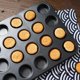 thumbnail image 4 of Molde antiadherente para 24 mini muffins con asas extendidas para un agarre fácil, de acero al carbono para una cocción uniforme, apto para lavavajillas (negro), 4 of 5