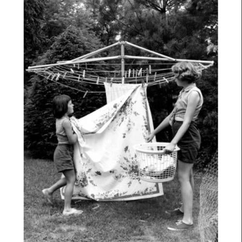 Mother and daughter hanging laundry in backyard Poster Print (18 x 24)