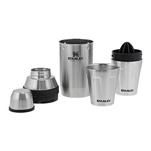set de coctelera stanley sistema adventure happy hour 2x 2 acero inoxidable: kit plateado todo en uno con vaso mezclador alto con logo Stanley, jigger integrado, vaso de rocas y tapa con exprimidor cítrico desmontable y colador; piezas alineadas sobre fondo blanco, apto para preparar y servir cócteles en exteriores o en casa, también suele usarse para hacer bebidas individuales al viajar.