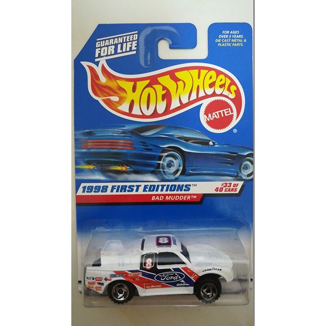 hot wheels-ford ranger raptor f-150 svt lightning 49 f1, coche de metal fundido a presión 1/64 en blister; auto blanco con gráficos rojos y azules, número 8 en el techo, logos Ford en las puertas, ruedas cromadas y empaque azul Hot Wheels "1998 First Editions" visible; a menudo usado como pieza de colección en vitrinas de escala 1:64.