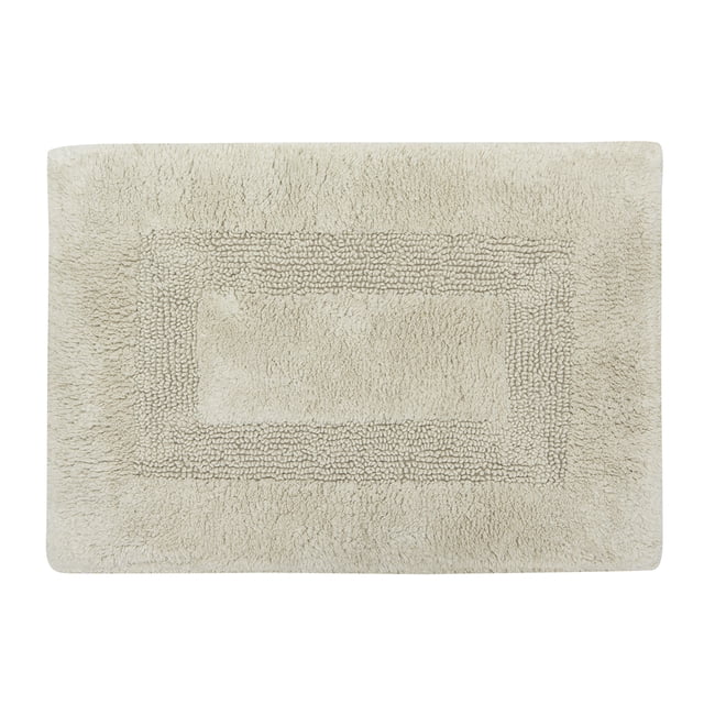 Beige rectangular Mainstays Racetrack bath rug with textured border and center, 17 by 24 inches.