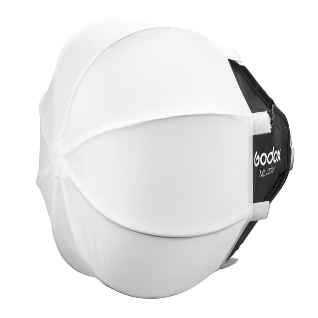 linterna plegable softbox godox ml100bi, modificador de luz blanca en vista 3/4; softbox octagonal blanco con paneles de difusión cosidos, cuerpo trasero negro con logo Godox y texto ML100Bi, correas de velcro y rieles plegables para montaje rápido, diseñado para retratos y video y a menudo usado como modificador portátil para tomas en locación.