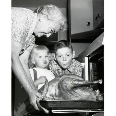 Posterazzi SAL255688 Side Profile of a Senior Woman Taking a Roasted Turkey Out of an Oven with Her Grandchildren Looking Surprised - 18 x 24