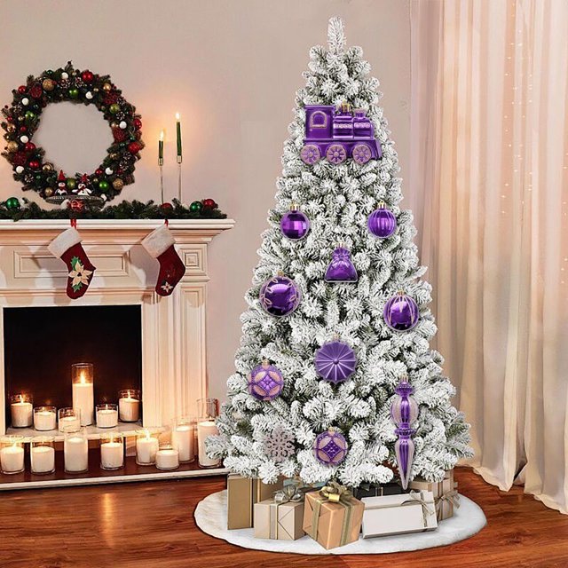 fiudx juego de bolas navideñas, 60 piezas de adornos galvanizados color morado; árbol nevado visto de frente con esferas moradas metálicas, copos de nieve colgantes y adorno con forma de tren en la punta, colgantes geométricos y texturizados, sala con chimenea, corona y regalos en la base. A menudo usado como centro de mesa decorativo para mesas pequeñas o coronas navideñas.