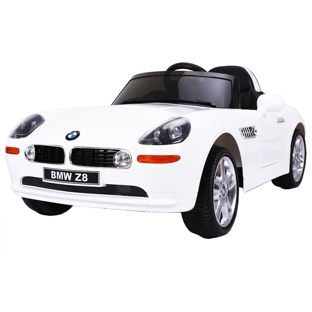 carrito montable eléctrico bmw z8 blanco unitalla coche infantil 3/4 frontal con emblema BMW, parrilla y faros encendidos, luces direccionales naranjas, parabrisas tintado, retrovisores laterales y puertas abatibles; volante y asiento negros con cinturón de seguridad, rines plateados. Control remoto (~5 m) y modo manual, MP3 (solo AUX), 6 V, velocidad 1 km/h, medidas 111 x 55 x 35 cm; a menudo usado también para exhibición o sesiones fotográficas de juguetes.
